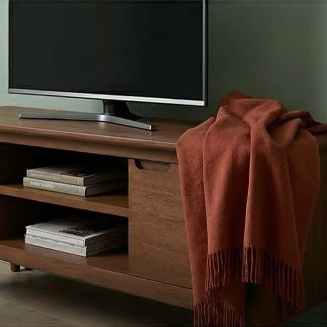 Fishe & Lilly Norway Dark Walnut TV Stand & Media Unit with a TV, books on shelves, and a draped blanket