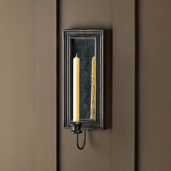 Pooky - Degas Wall Mounted Candle Holder - Ebony with a candle and antiqued mirror on a dark wall.