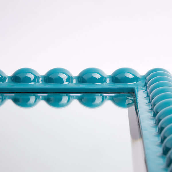 Pooky - Charming Mirror - Turquoise close-up of turquoise carved wooden frame with textured detailing.
