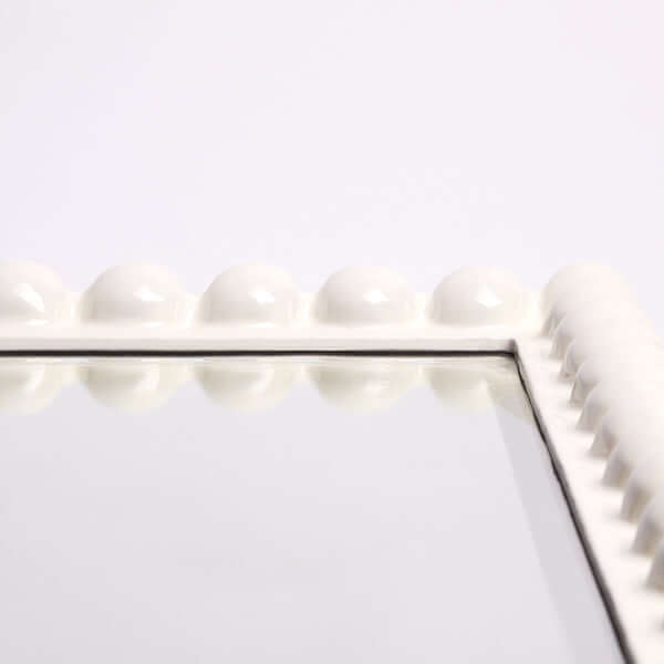 Pooky - Charming Mirror - White close-up of playful carved white frame with spherical detailing