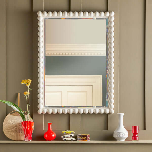 Pooky - Charming Mirror - White displayed on a shelf with colorful vases and decor items.