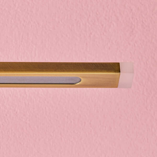 Pooky - Regular Blake Rechargeable Picture Light - Brass on a pink wall, showcasing its elegant antique brass design.