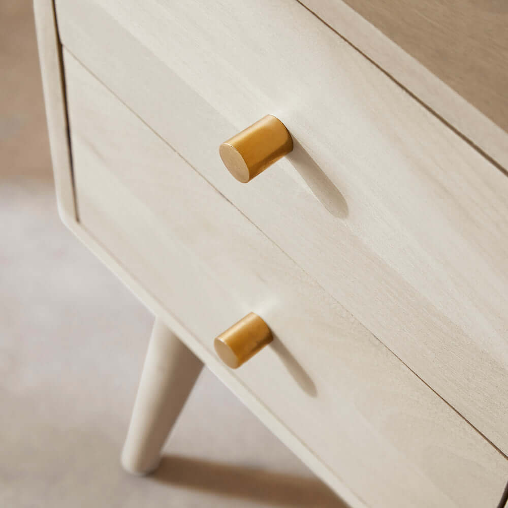 Brass drawer pulls on the Fishe & Lilly Minimalist Mango Wood White Logan Narrow Bedside Table.