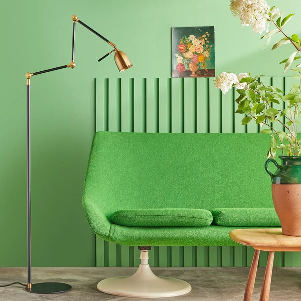 Flexible Pooky - Pick Reading Lamp - Black And Antiqued Brass next to a green sofa