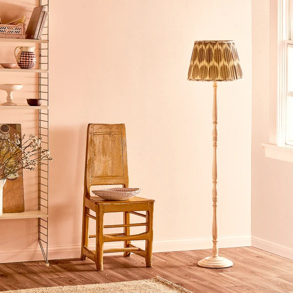 Pooky - Otto Rechargeable Standing Lamp Base - Cream - Without Lampshade next to a wooden chair.