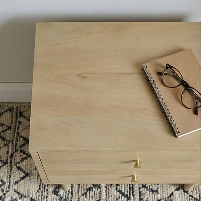 Top surface of Fishe & Lilly Minimalist Mango Wood Oslo Bedside Table showing light oak finish and brass knobs.