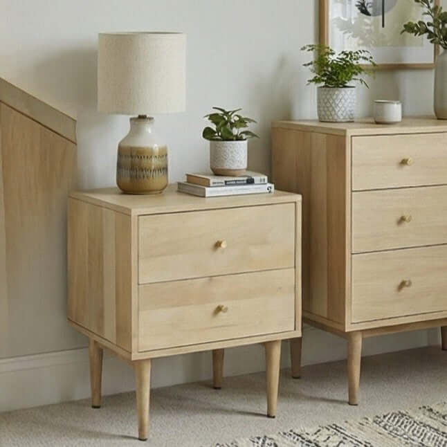 Light oak finish Fishe & Lilly Minimalist Mango Wood Oslo Bedside Table with two drawers, brass knobs, and tapered legs.