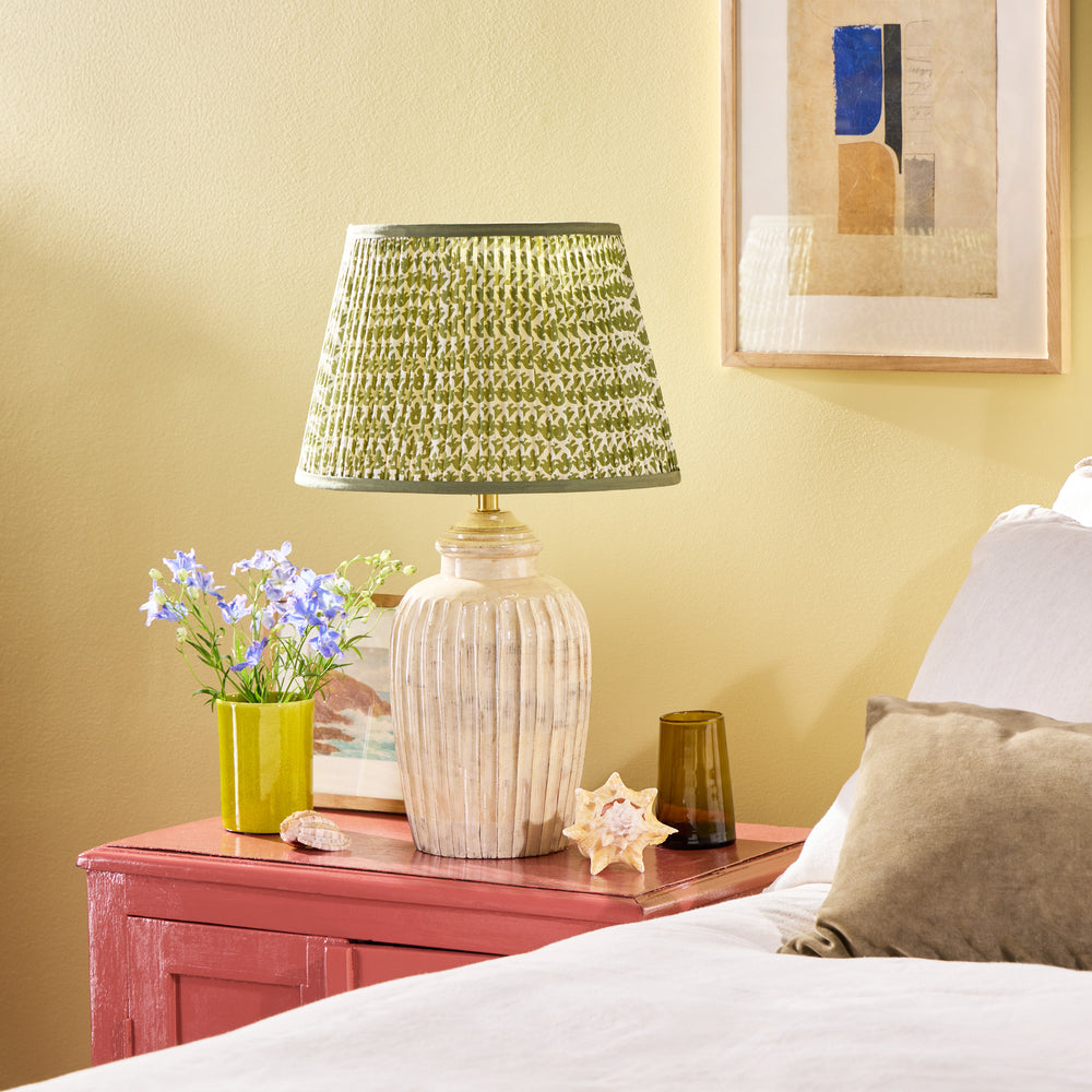 Pooky - Smaller Marcie Table Lamp Base - Natural Whitewash on a pink bedside table with a green patterned shade.