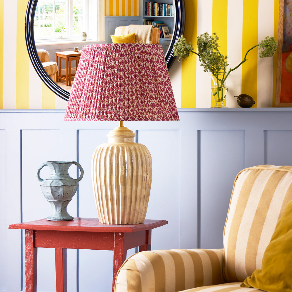 Pooky - Larger Marcie Table Lamp Base - Natural Whitewash with a red patterned shade on a red table.