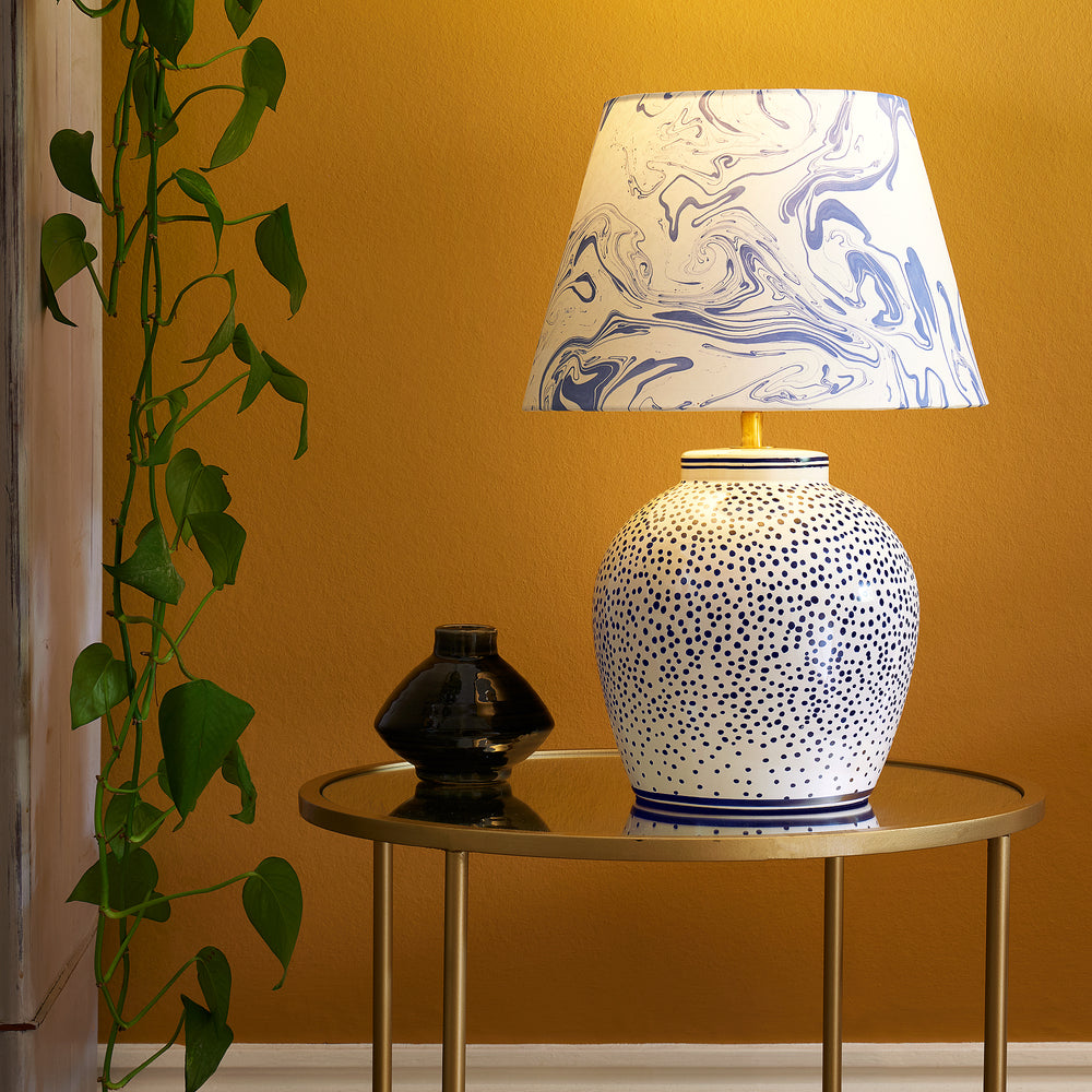 Pooky - Polka Table Lamp Base - Blue and White paired with a marbled shade on a glass table.