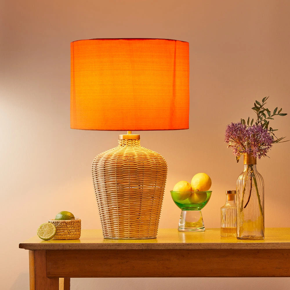 Pooky - Regular Rattle Table Lamp Base - Natural Cane paired with an orange shade.