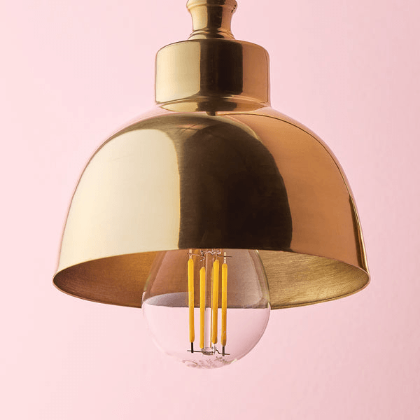 Pooky - Carmel Wall Light - Antiqued Brass Finish stylish lamp design with clear bulb and brass shade.