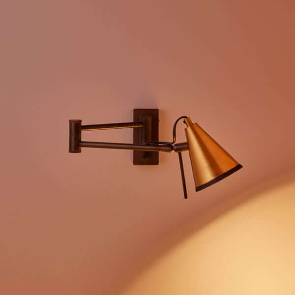 Pooky - Conrad Articulated Wall Light in Bronze with Brass Hood - Bronze and Brass mounted on a wall with warm light.