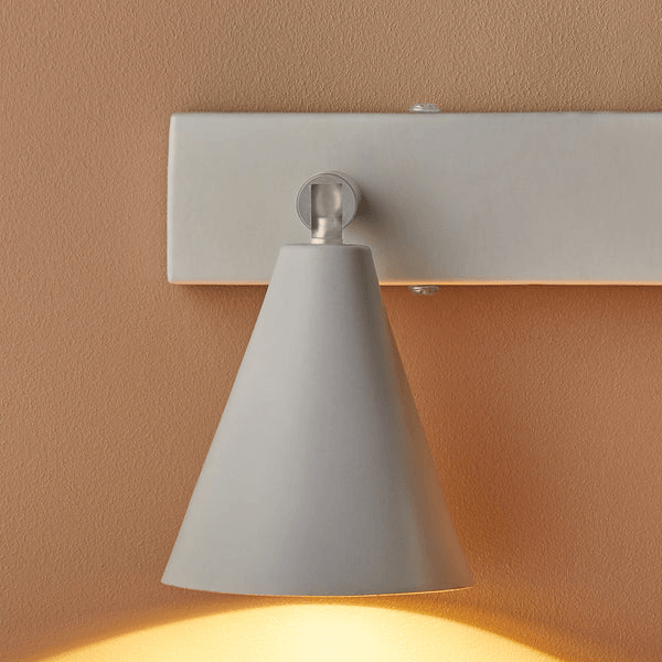 Pooky - Crick Triple Wall Spotlight - Paintable Finish elegantly mounted on a wall with a soft beige background.