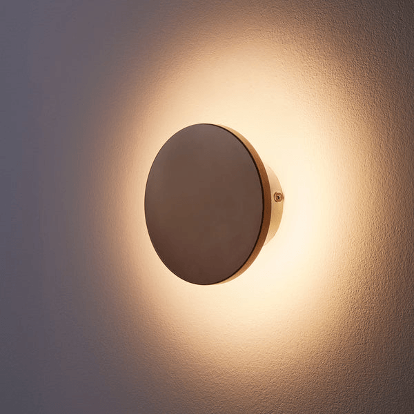 Pooky - Helios Ip44 Wall Light - Smaller - Brushed Bronze Aluminium illuminating a wall with a warm glow.