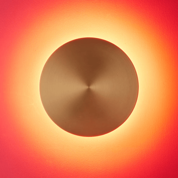 Pooky - Helios Ip44 Wall Light - Larger - Brushed Gold Aluminium illuminating a warm glow on the wall.