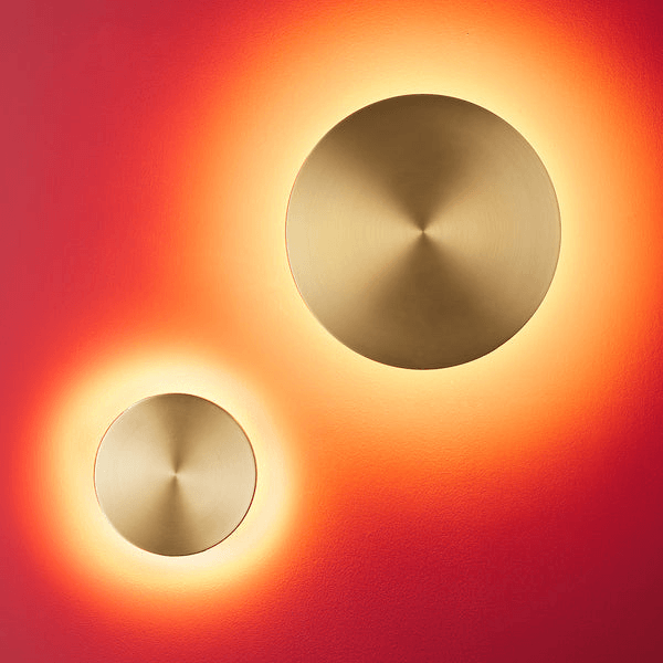 Pooky - Helios Ip44 Wall Light - Larger - Brushed Gold Aluminium illuminating a wall with a warm glow