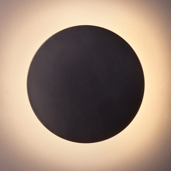 Pooky - Helios Ip44 Wall Light - Largest - Bronze Aluminium featuring a sleek circular design emitting a warm glow.