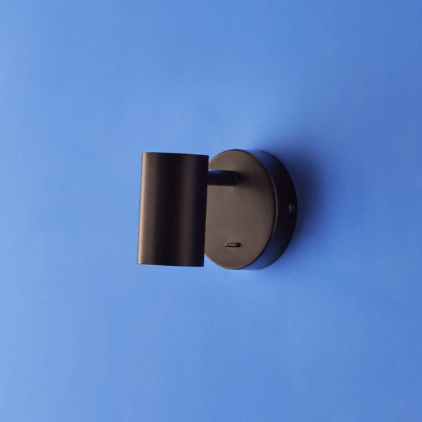 Pooky - Lewis single Wall Light - Black - With switch mounted on a blue wall.