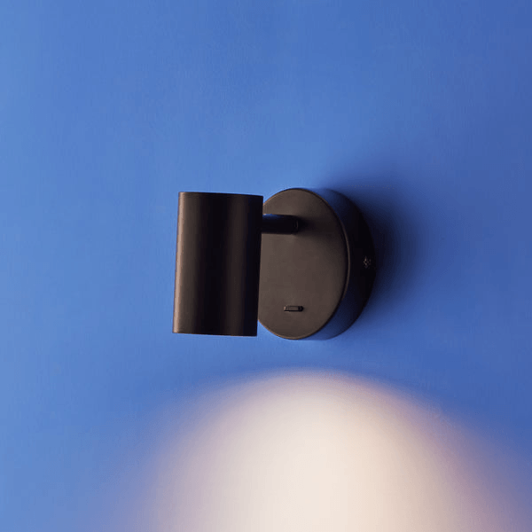 Pooky - Lewis single Wall Light - Black - With switch mounted on a blue wall.
