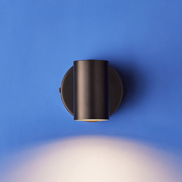 Pooky - Lewis single Wall Light - Black - With switch mounted on blue wall with adjustable beam.