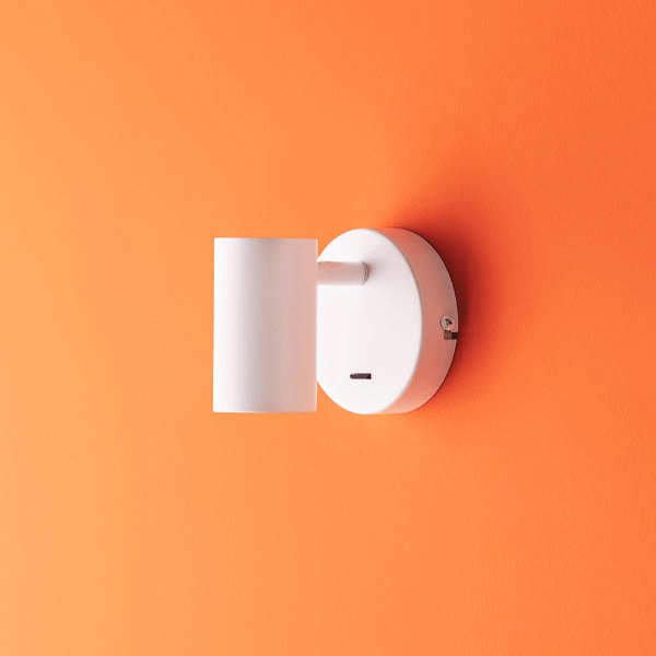 Pooky - Lewis single Wall Light - White - With switch mounted on an orange wall.