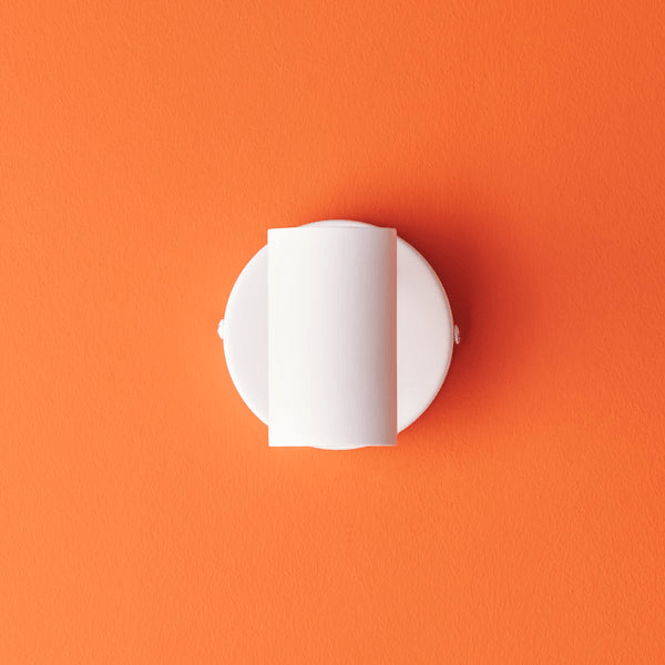 Pooky - Lewis single Wall Light - White - With switch mounted on orange wall background.
