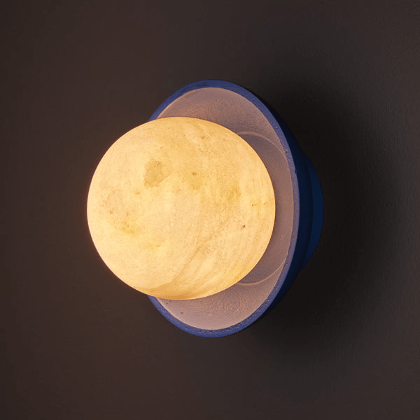 Pooky - Luna Wall Light - Klein Blue illuminating a dark wall with a soft, warm glow.