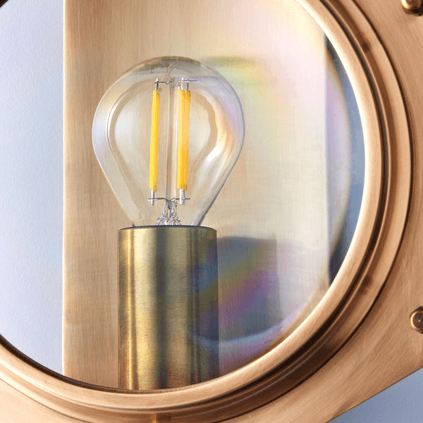 Pooky - Poirot Wall Light - Brass And Glass showcasing a stylish bulb with yellow filaments and elegant brass mount.