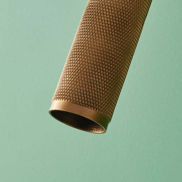 Pooky - Quantum Single Wall Light - Antiqued Brass close-up showcasing knurled texture and detail.