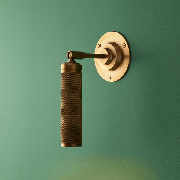 Pooky - Quantum Single Wall Light - Antiqued Brass mounted on green wall.