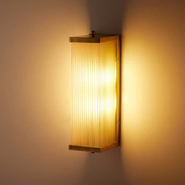 Pooky - Rectangular Roddy ip44 Rated Wall Light - Brass and Frosted Glass illuminated on a wall.