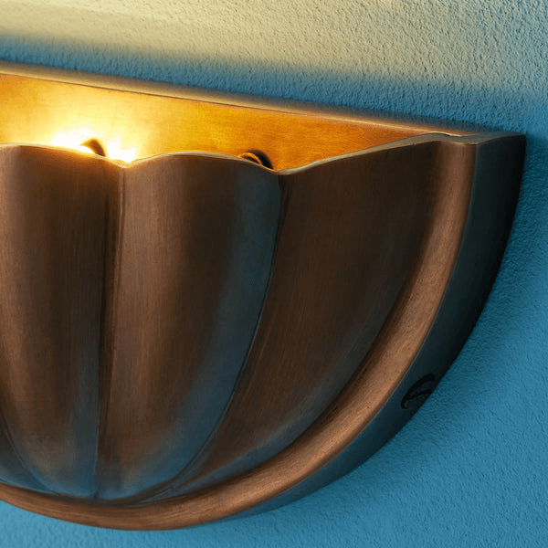 Pooky - St Jacques Wall Light - Smaller - Brass wall sconce with scallop shell design illuminating a wall.