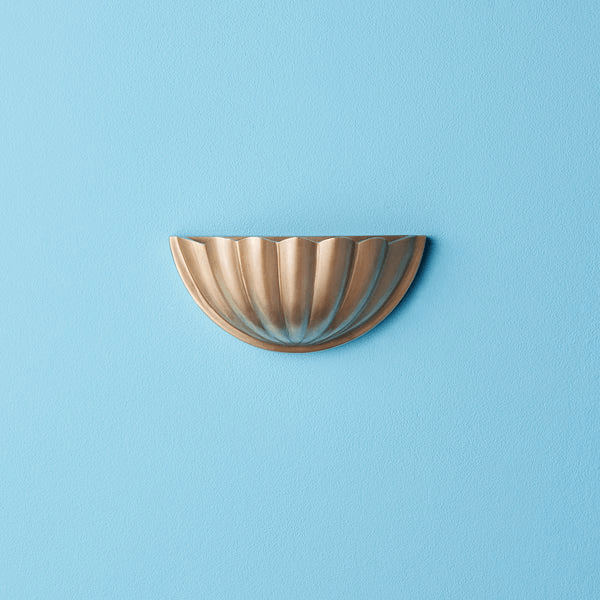 Pooky - St Jacques Wall Light - Smaller - Brass mounted on a blue wall, showcasing its scallop shell design in polished brass.