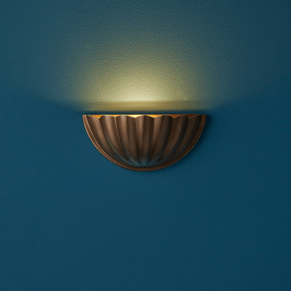 Pooky - St Jacques Wall Light - Smaller - Brass illuminating a blue wall with its elegant scallop shell design.