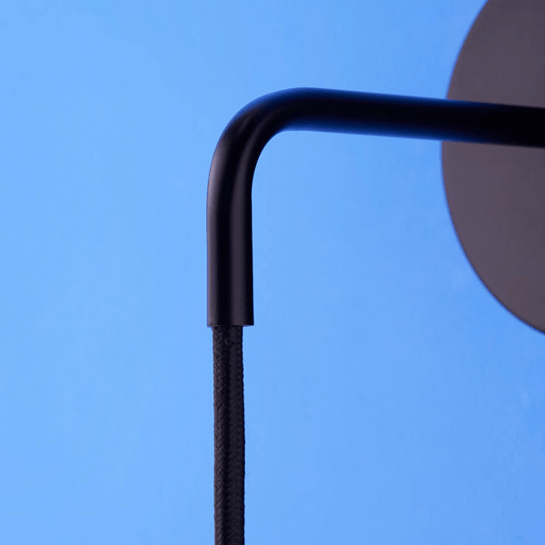 Close-up of the Pooky - Sway Wall Light - Black showcasing the sleek black arm and cord detail.