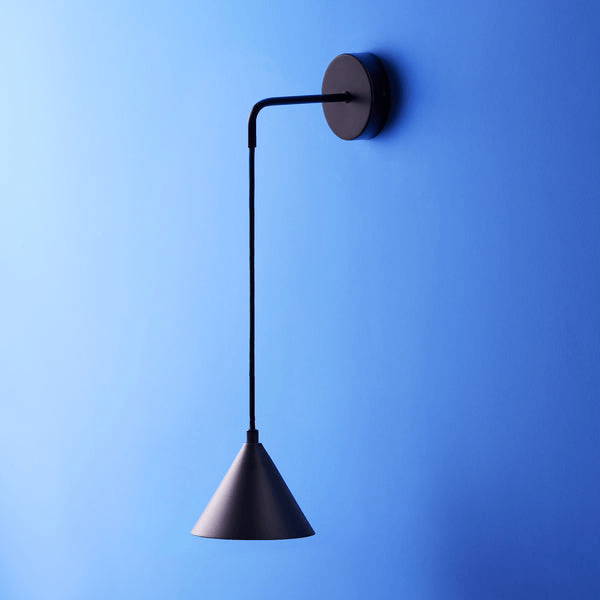 Pooky - Sway Wall Light - Black hanging against a blue wall, showcasing a stylish design with a deep black finish.