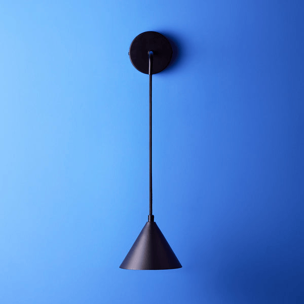 Pooky - Sway Wall Light - Black hanging against a blue wall, showcasing its modern and stylish design.