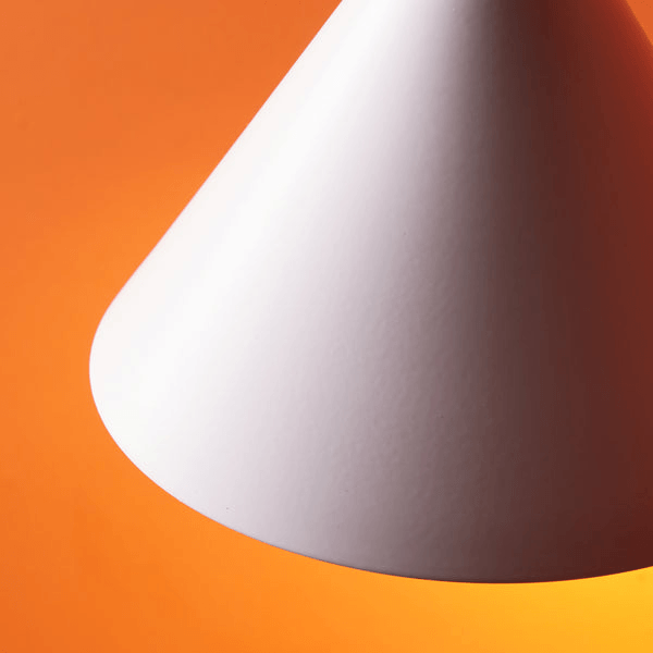 Pooky - Sway Wall Light - White lamp design with a cone shape against an orange background.