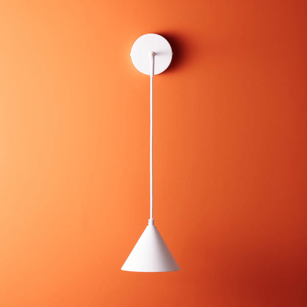 Pooky - Sway Wall Light - White hanging on an orange wall, showcasing its stylish design and simplicity.