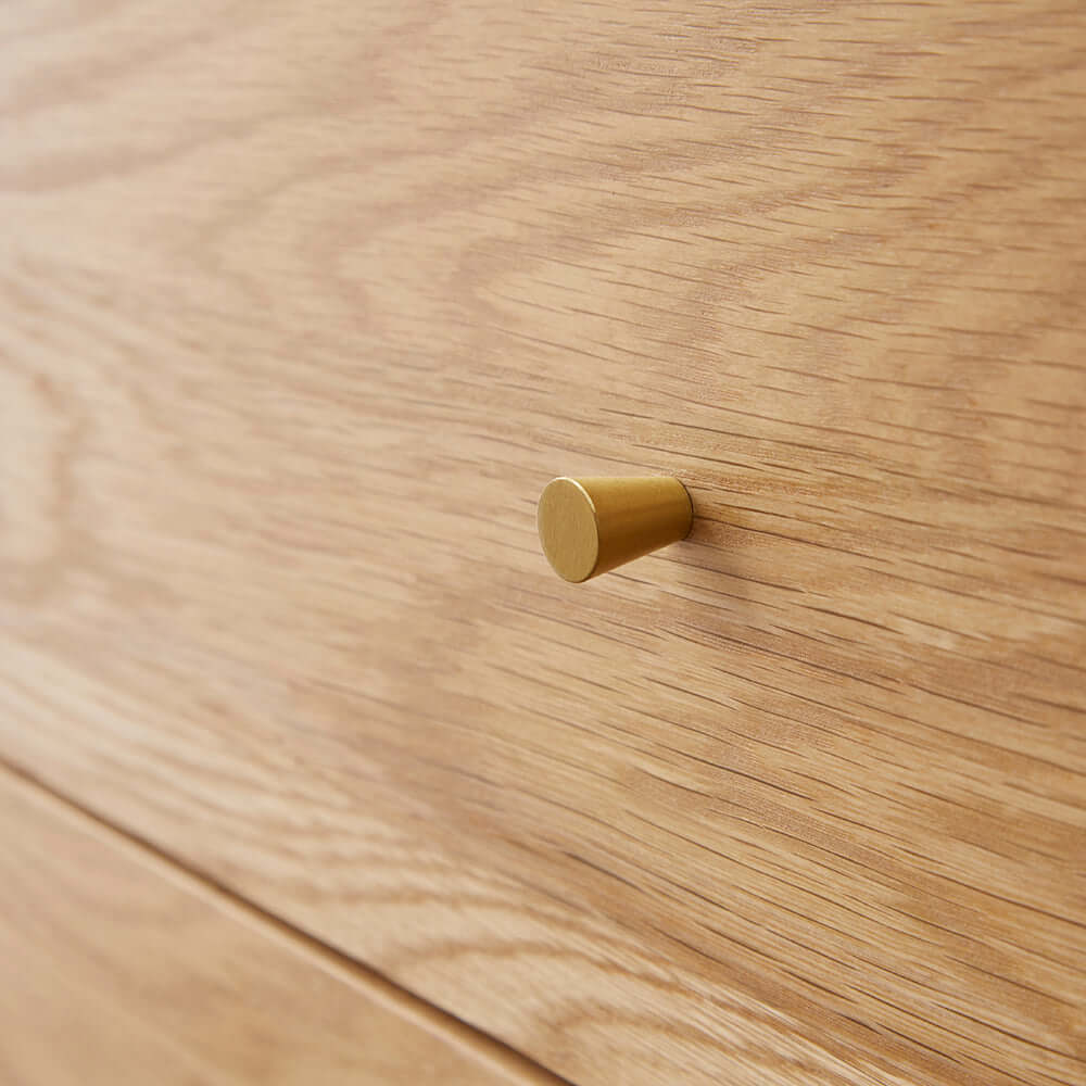 Close up of the sophisticated brass handle and natural oak grain on the Fishe & Lilly Wright Oak Chest of 3 Drawers.