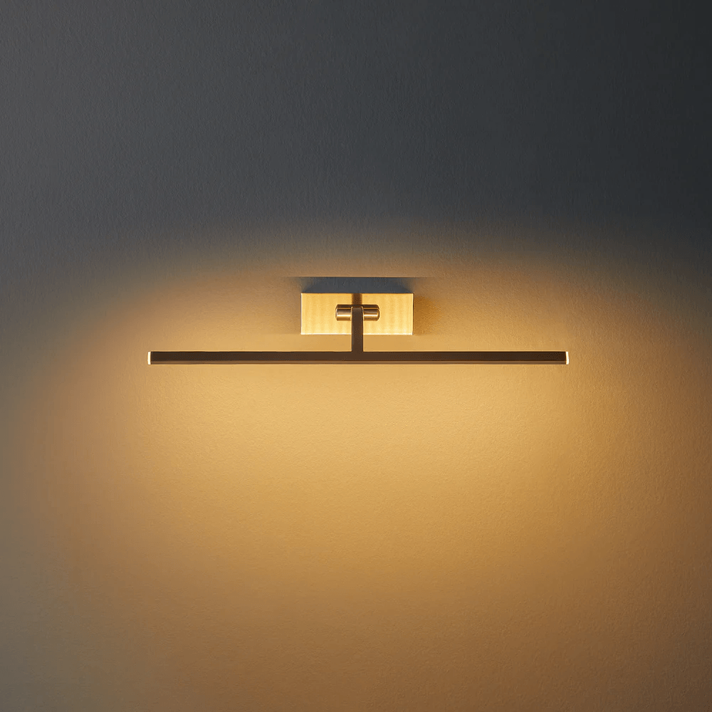 Pooky - Blake Dimmable Picture Light - Medium - Brushed Chrome Finish mounted on a wall, casting warm light.