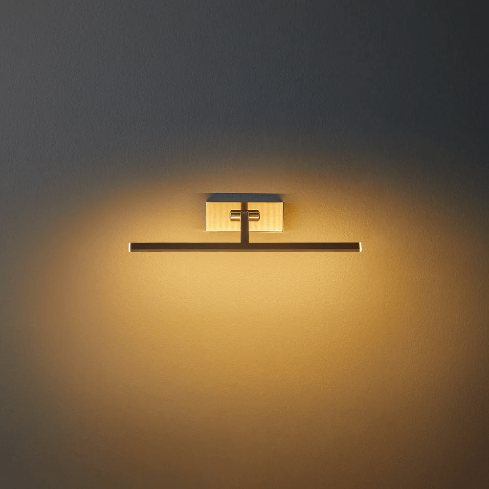 Pooky - Blake Dimmable Picture Light - Smaller - Brushed Chrome Finish mounted on the wall, casting warm light.
