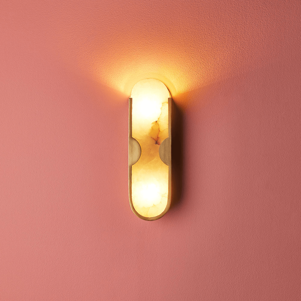 Pooky - Epicurus Alabaster Wall Light illuminating a pink wall with warm hues of alabaster and brass.