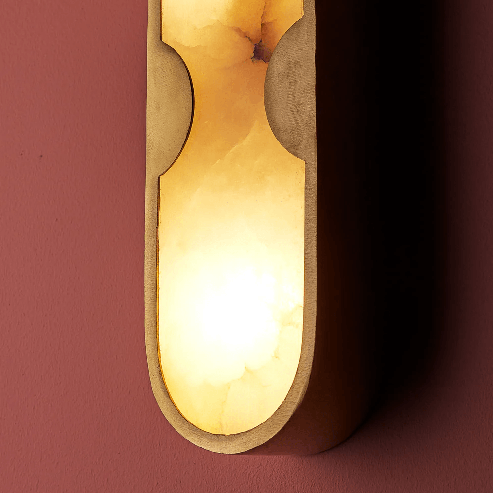 Pooky - Epicurus Alabaster Wall Light illuminating a wall with a warm glow, featuring elegant alabaster and brass design.