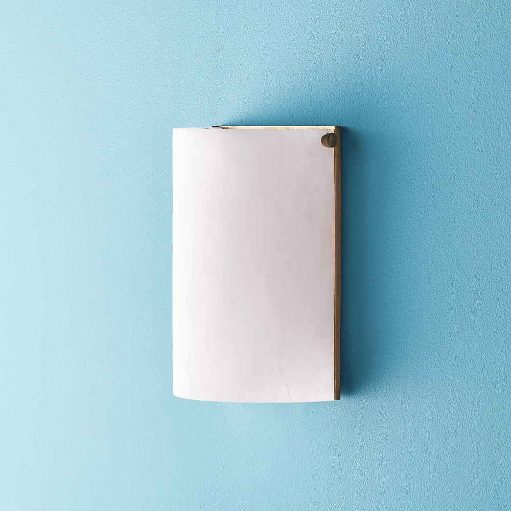 Pooky - Zeno Alabaster Wall Light mounted on blue wall, showcasing its unique alabaster design.