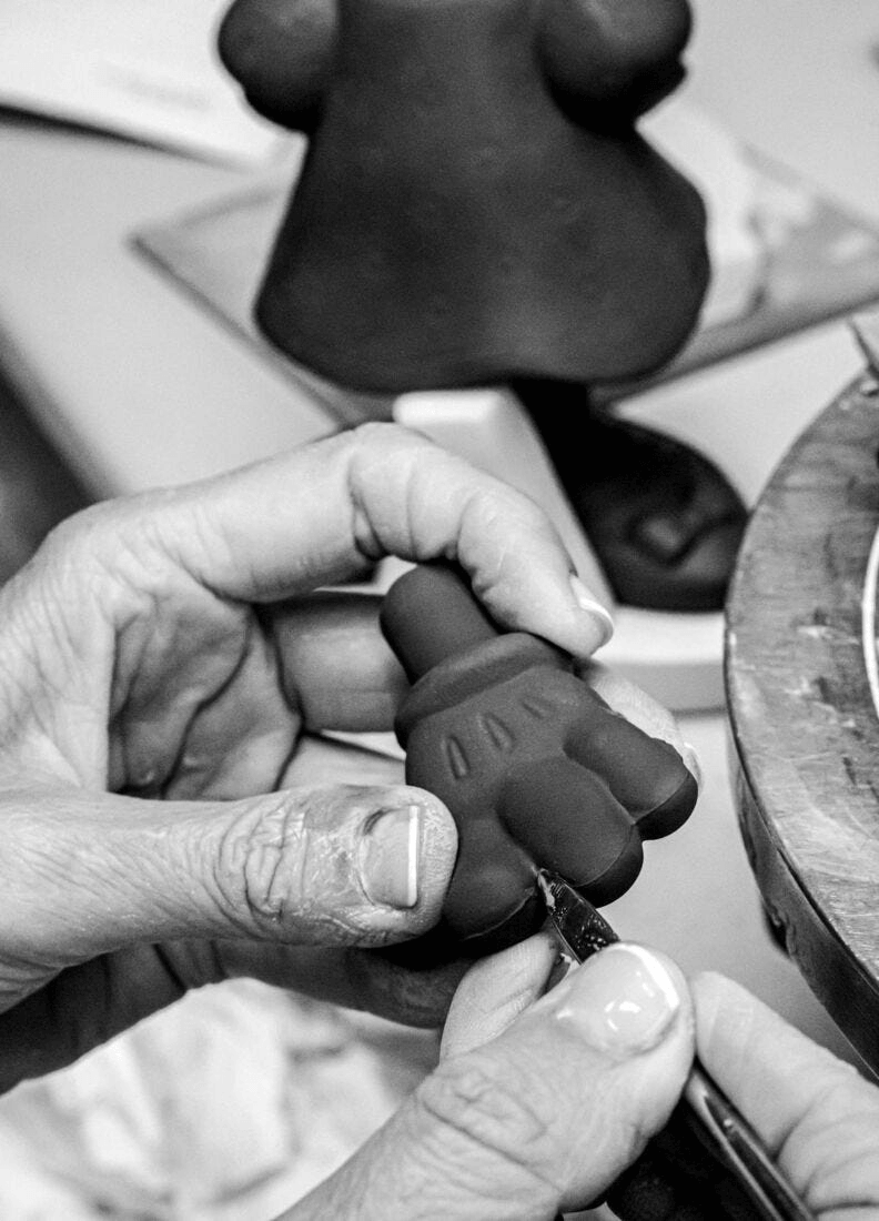 Artist crafting the Lladró - Minnie Total Black Sculpture in black porcelain, showcasing meticulous detail and artistry.