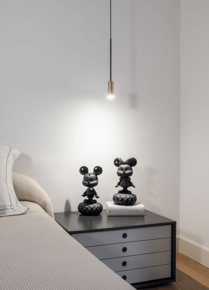 Lladró - Minnie Total Black Sculpture displayed on a bedside table with a modern lamp.