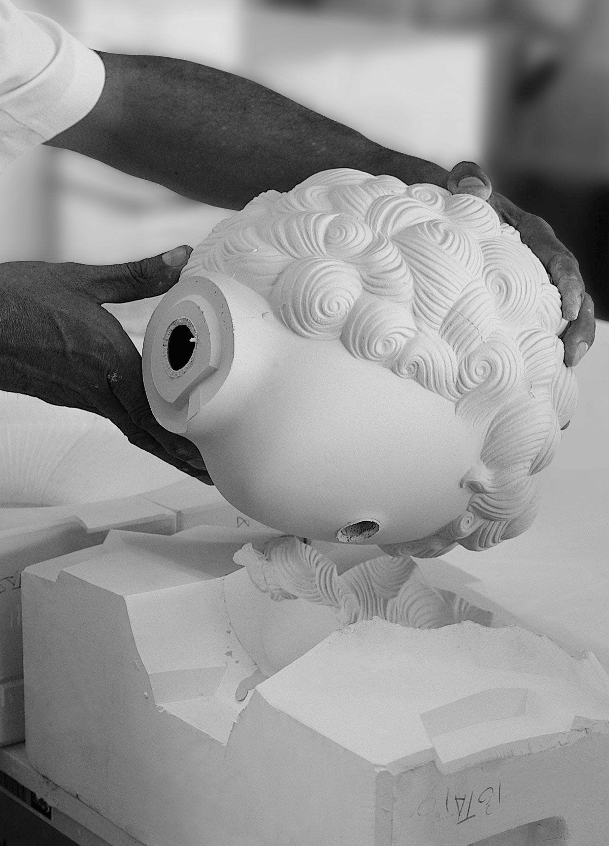Artisan lifting a Porcelain head from a mold for Lladro piece: Lladró - The Clown Table Lamp.