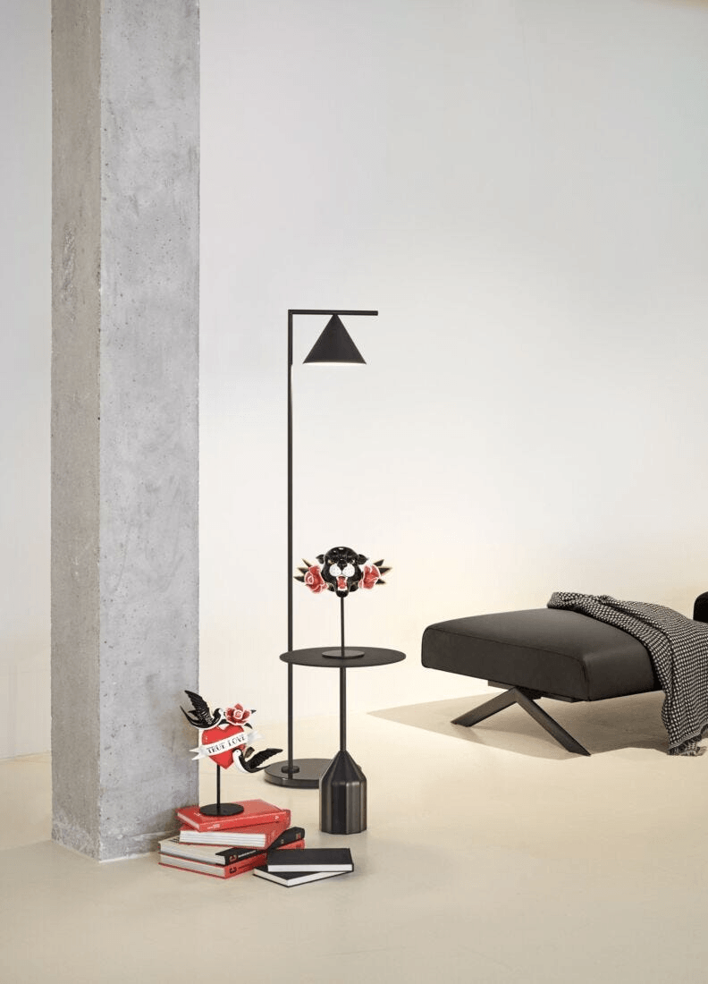 Stylish modern living room with a Lladró - Wild Panther Figurine, books, and minimalist lighting.